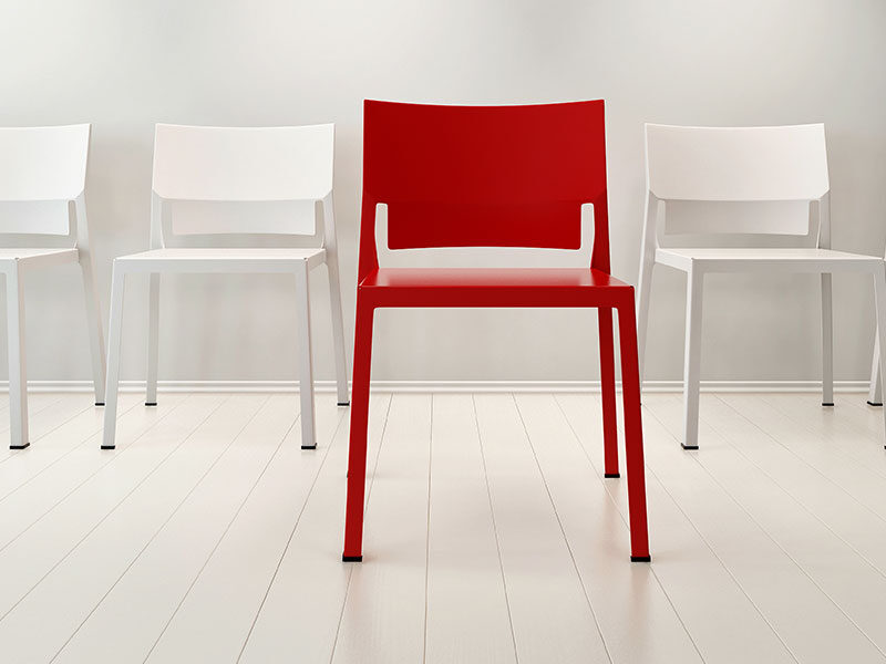 single red chair amongst white chairs